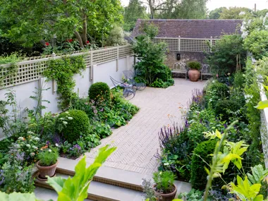 Septima Aureum clay pavers create magical pathways edged with soft romantic planting